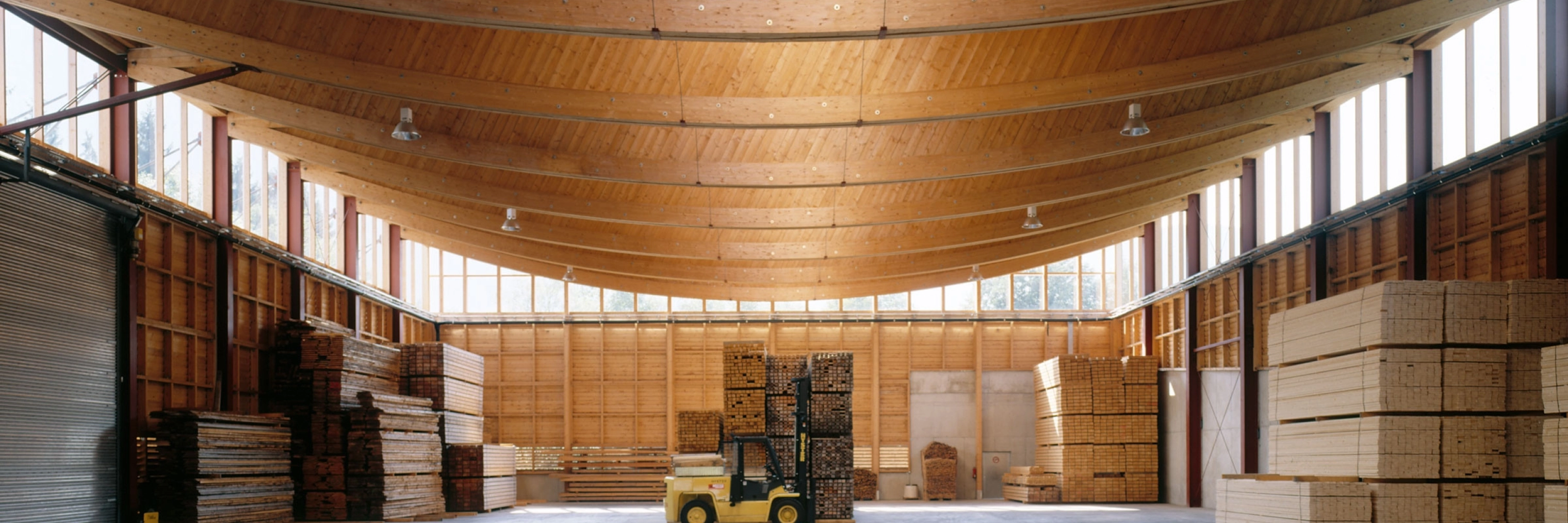 Lagerhalle mit Holzstapeln und Gabelstapler